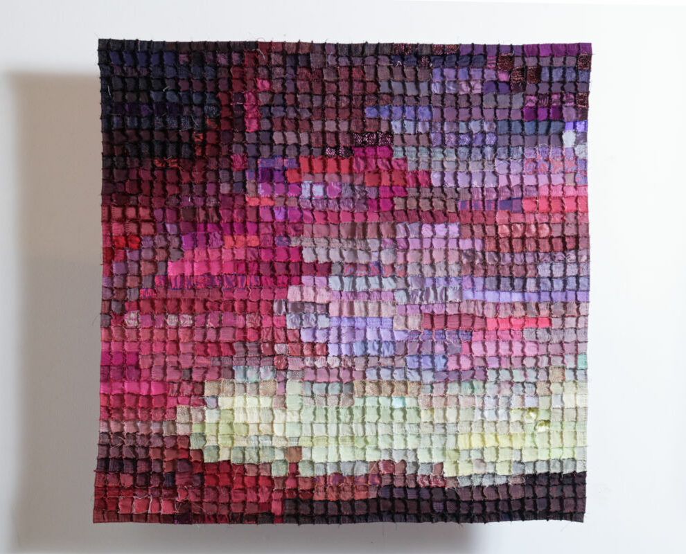 Sabine Cibert Boréale 295 ©Pascal Muradian Textured mosaic quilt artwork with small square patches in a gradient from deep purple to pink to pale yellow on a white wall