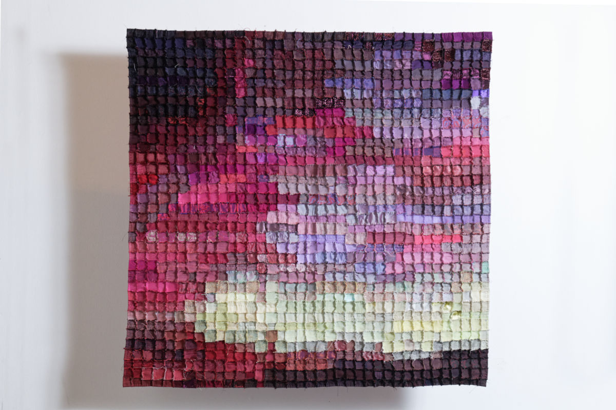 Sabine Cibert Boréale 295 ©Pascal Muradian Textured mosaic quilt artwork with small square patches in a gradient from deep purple to pink to pale yellow on a white wall