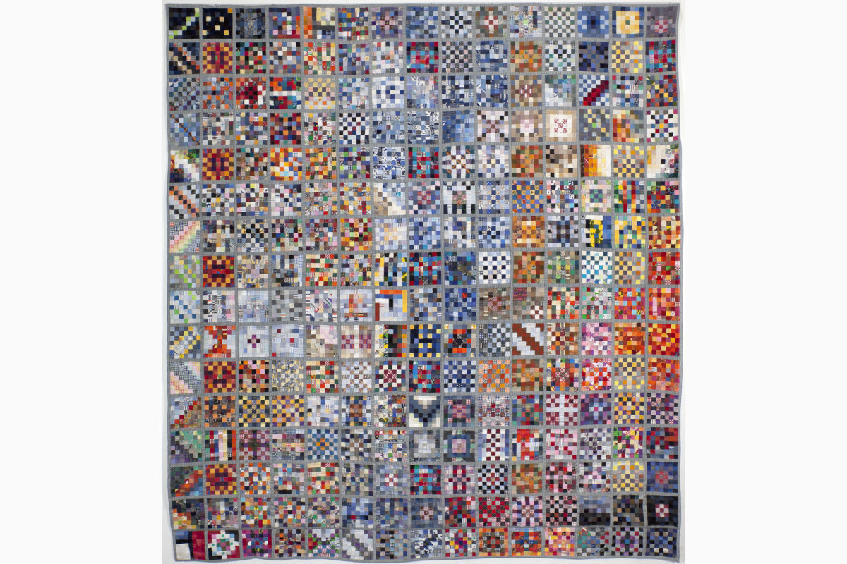 Sabine Cibert Pluriel ©Philippe-Liev Pourcelot Large patchwork quilt made of hundreds of colorful square patches arranged in a grid.
