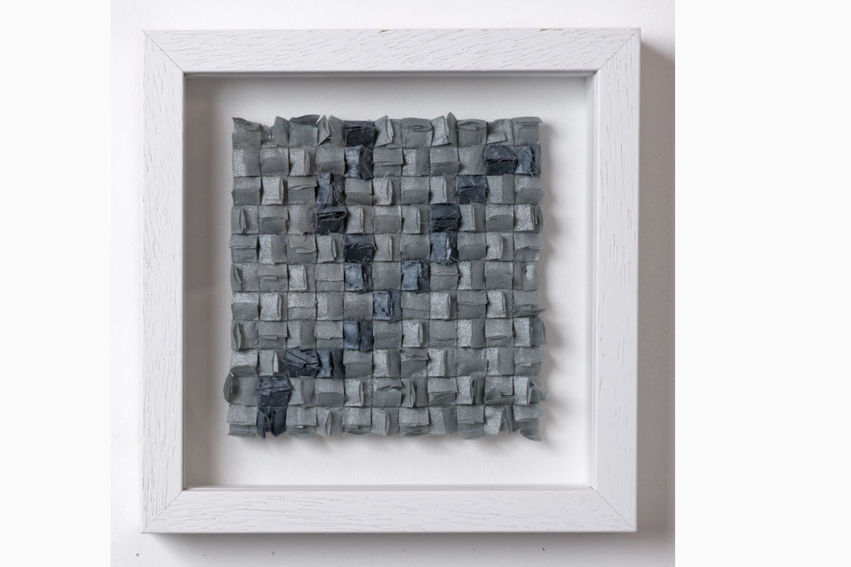 Sabine Cibert - Orage 304 ©Pascal Muradian Framed square mosaic artwork made of small gray and blue folded squares in a white frame as wall art.